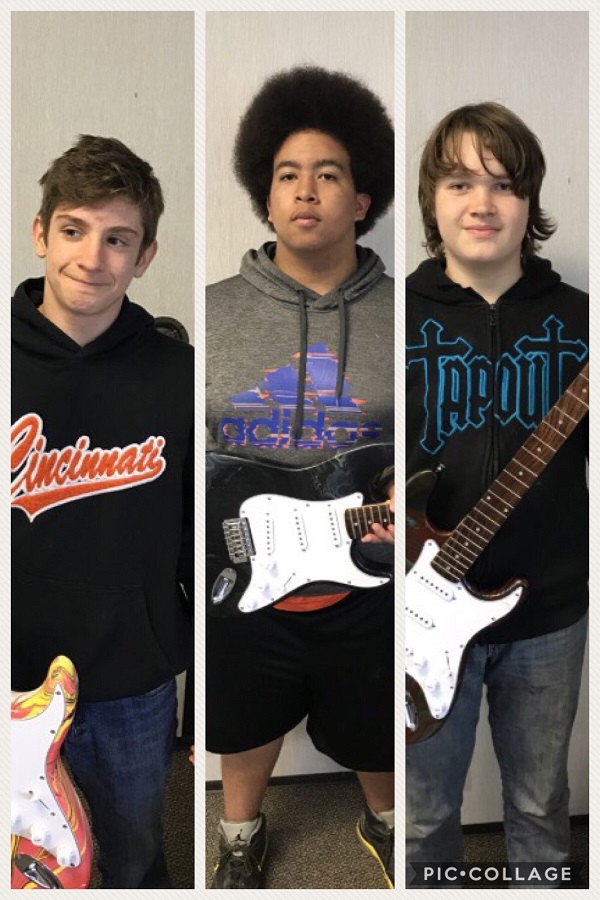 image of three boys holding guitars